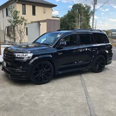 a black suv parked in front of a house