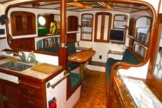 the inside of a boat with wood flooring and wooden cabinets on both sides of it