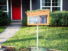 a sign in front of a house with a book shelf on it's side