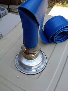 a blue hose is attached to the top of a boat's engine cover on a table