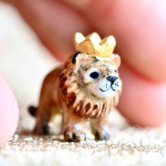 a tiny toy lion with a crown on it's head and the words, the pride of little hope