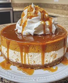 a cheesecake covered in caramel and whipped cream