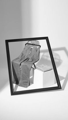 a black and white photo of a pair of jeans in a frame on the floor