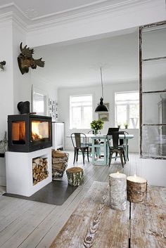 a living room filled with furniture and a fire place next to a dining room table