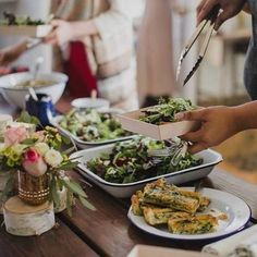 people are serving themselves food at a table