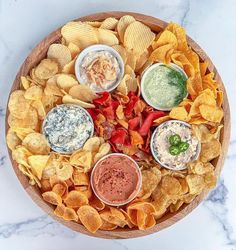 a wooden bowl filled with chips and dips