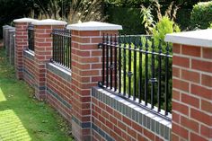 a brick fence with wrought iron railings