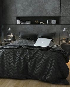 a laptop computer sitting on top of a bed next to a night stand and lamp