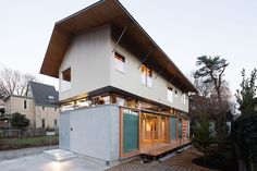 a modern house with an open floor plan and large windows on the top level is surrounded by trees