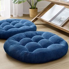 two round blue cushions sitting on the floor