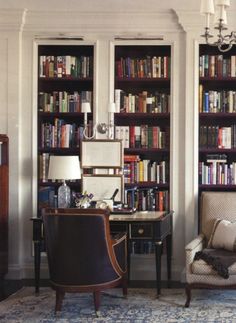 a living room filled with lots of books on top of a book shelf next to a chair