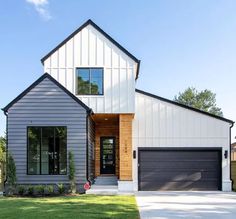 a white house with two garages on the front and one door open to let in lots of light