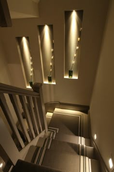 an overhead view of a staircase with lights on the ceiling and carpeted flooring