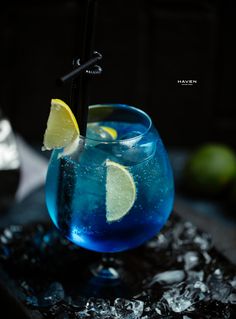 two glasses filled with blue liquid and lemon wedges