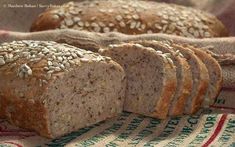 sliced loafs of bread sitting on top of a tablecloth covered with burlies