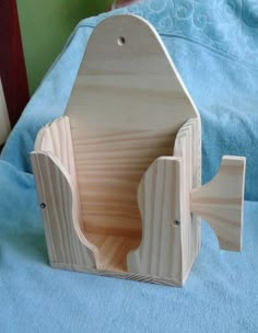 a wooden toy house sitting on top of a blue bed sheet with a fish in it