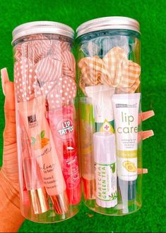 two jars filled with different types of toothbrushes and lip care products next to each other