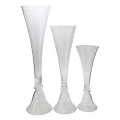 three tall white vases sitting next to each other