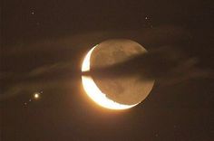 the moon is partially obscured by clouds as it passes in front of an earth - like object