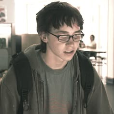 a young man wearing glasses and a backpack