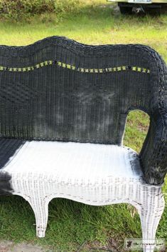 a black and white bench sitting on top of a grass covered field next to a truck