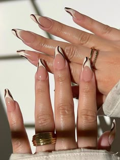 a woman's hand with long, shiny nails and gold rings on her fingers