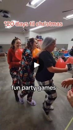 a group of people standing around each other in a room with balloons on the floor