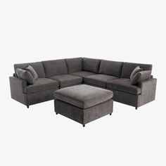 a gray sectional sofa with ottoman and footstool in front of a white background