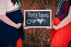 two pregnant women holding a sign that says they have ourss