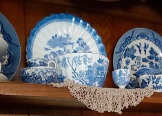 blue and white china is displayed on a shelf