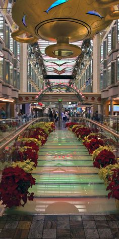 an indoor shopping mall with flowers on the floor