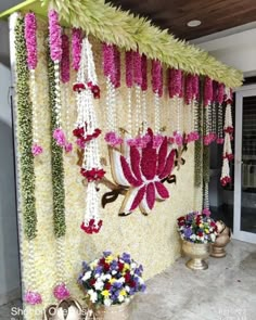 flowers are hanging from the side of a wall