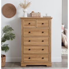 a wooden dresser sitting next to a plant in a room