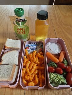 a lunch box with sandwiches, carrots, broccoli and other foods