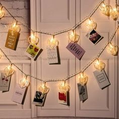 there is a string of lights that have been decorated with cards and tags on them