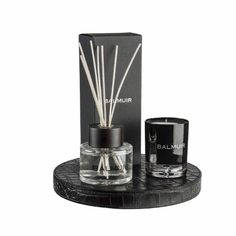 an image of a candle and reed diffuser on a black tray with a box