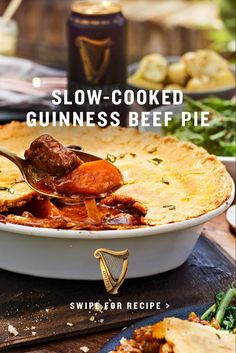 a close up of a pie on a plate with a spoon in it and the words slow - cooked guinness beef pie