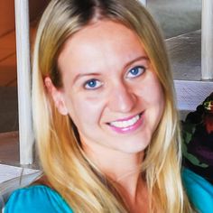 a woman with long blonde hair smiling at the camera