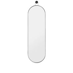 an oval mirror hanging on the wall with a black cord around it's edge