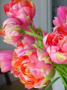 a vase filled with pink and orange flowers