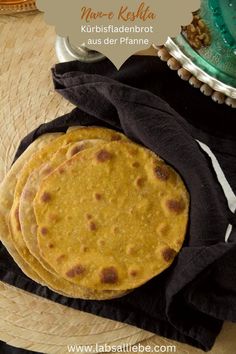 three tortillas sitting on top of a table next to a plate with food