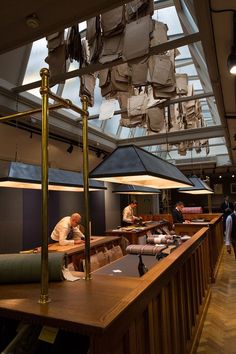 people are sitting at tables in a restaurant with lots of papers hanging from the ceiling