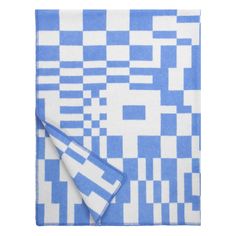 a blue and white checkered blanket folded on top of a table with a napkin