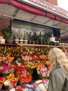 a woman standing in front of a flower shop