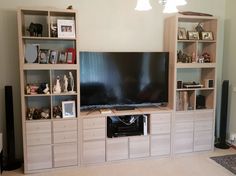 a living room with shelves and a flat screen tv on it's stand in front of the wall