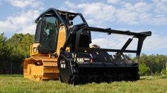 a tractor is parked in the grass on a sunny day