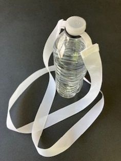 a water bottle with a white strap around it on a black surface, ready to be used as a gadget