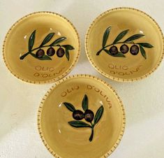 three yellow bowls with olives painted on them