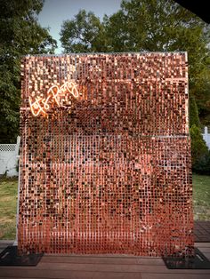 a sculpture made out of red bricks with graffiti on it