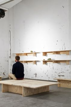 a man sitting on a bench in an empty room